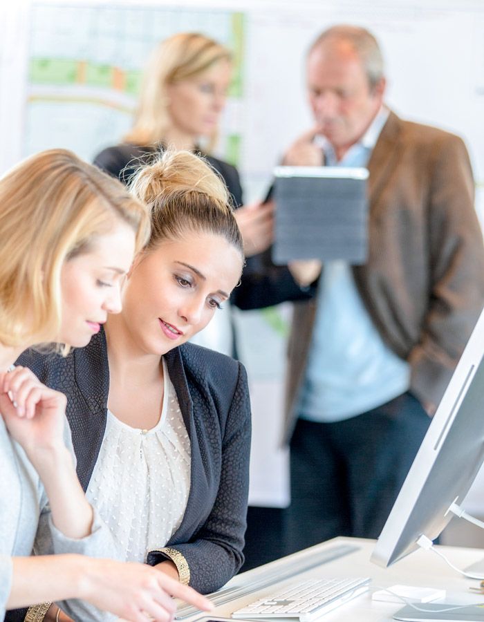 Businesspeople using laptop at conference table